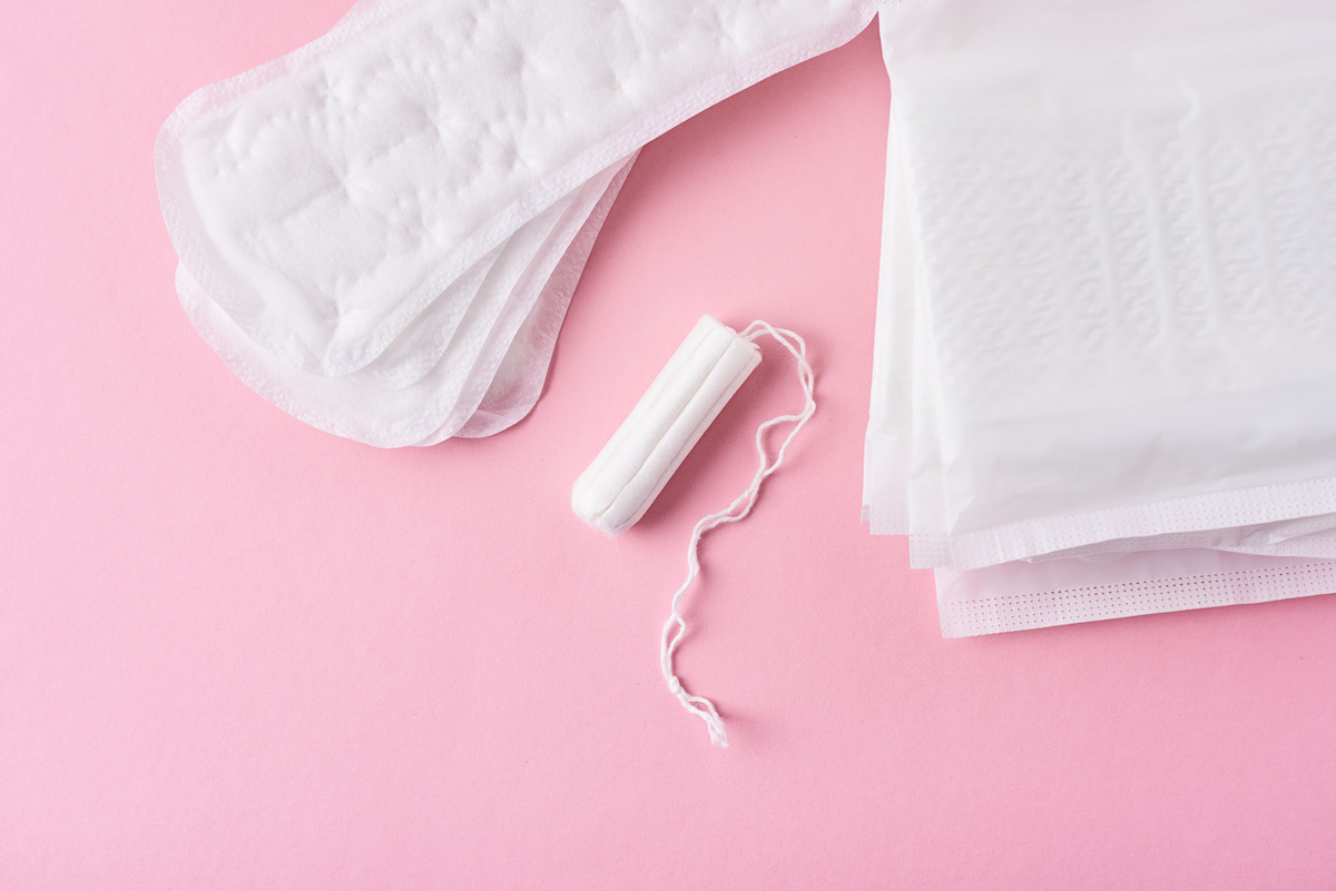 Sanitary pad and menstrual tampon on a pink background / blog - types of period products
