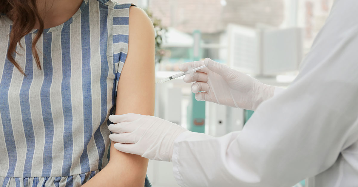 Young girl receiving vaccination in hospital; blog: What is the Recommended HPV Vaccine Schedule?