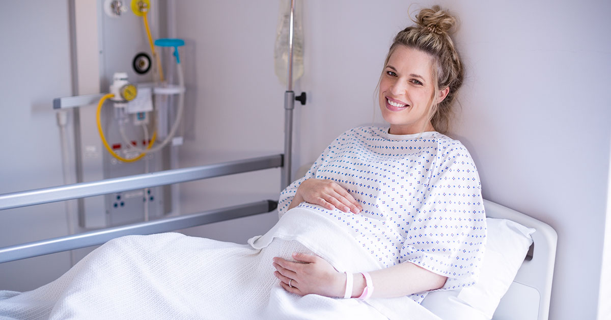 Portrait of pregnant woman relaxing on hospital bed; blog: Is VBAC Right for You?