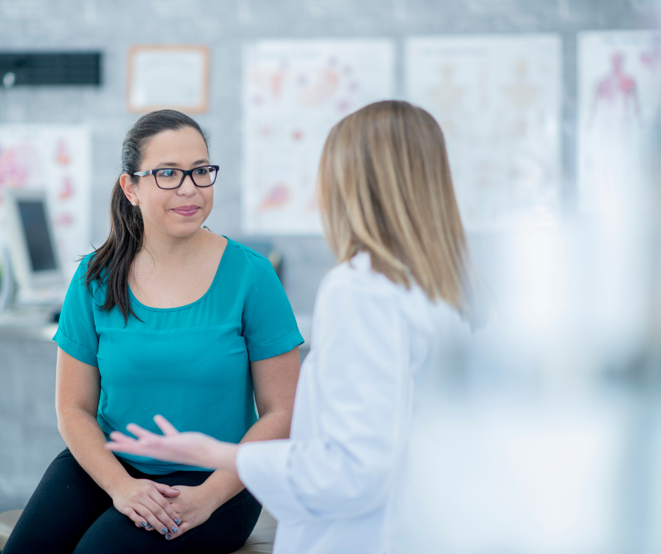 A gynecologist explain OB/GYN services to a patient in an office setting